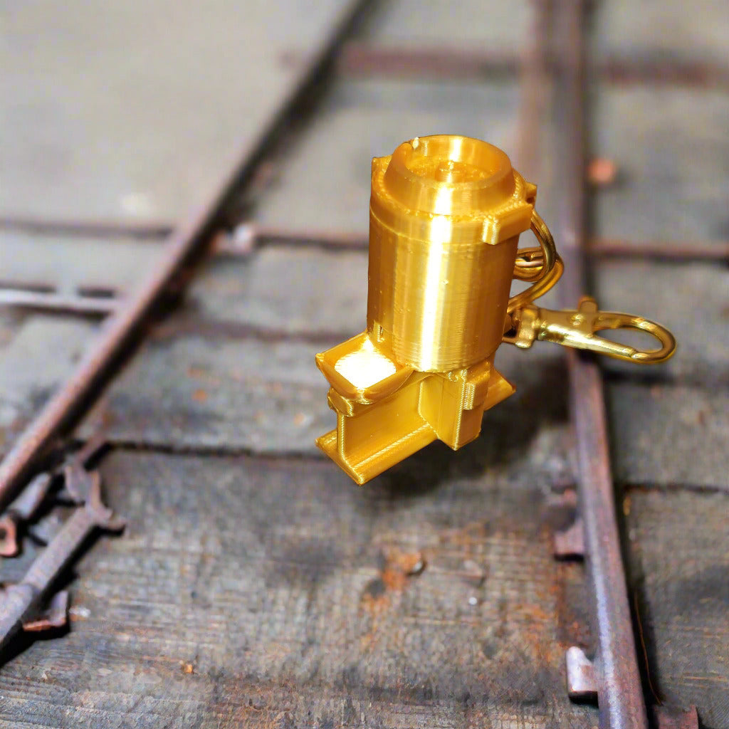 Gold-colored keychain with a unique design on a black background